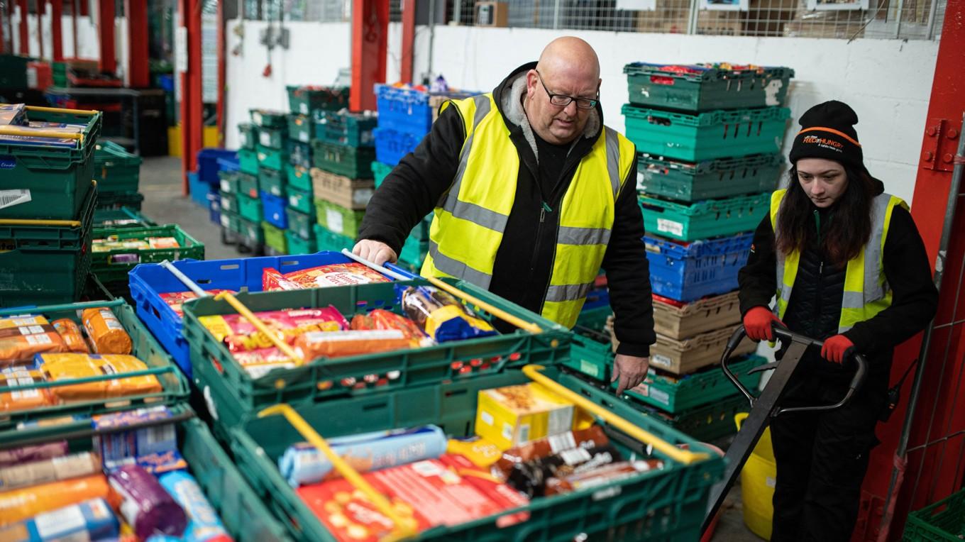 Personal plockar ihop matpaket som ska delas ut i de så kallade matbankerna till behövande britter. Foto: Oli Scarff/AFP via Getty Images