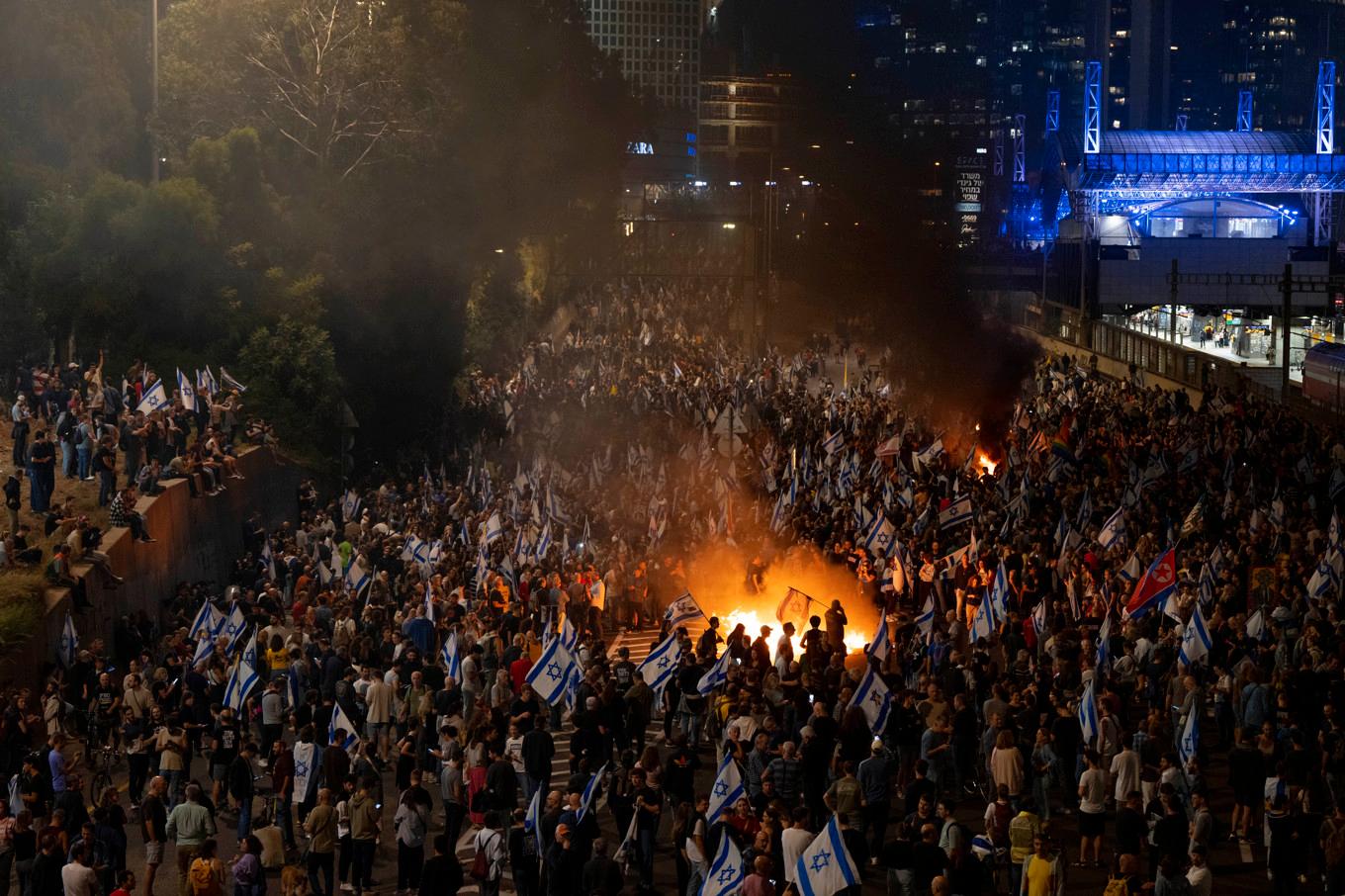 Demonstranter blockerar en motorväg i Tel Aviv på tisdagskvällen. Foto: Oded Balilty/AP/TT