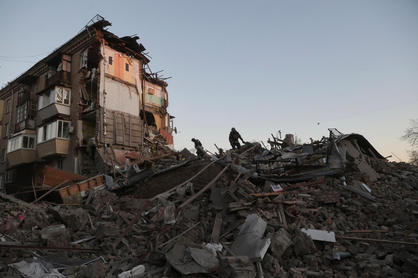 Räddningsarbetare jobbar i bråtet efter det att ett bostadshus träffats i en rysk attack under torsdagen. Foto: Kateryna Klochko/AP/TT