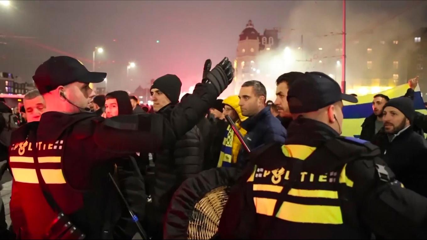 Polis eskorterar Maccabi Tel Aviv-fans till en tunnelbanestation i samband med tumultet på torsdagen. Stillbild från ett videoklipp. Foto: InterVision/AP/TT