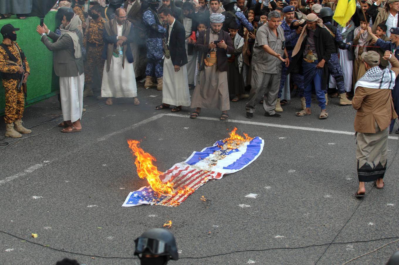 En amerikansk och en israelisk flagga sattes i brand vid en Huthiledd demonstration i Sanaa i fredags. Foto: Osamah Abdulrahman/AP/TT