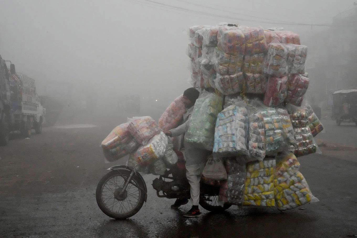 En försäljare kör genom smogen i den pakistanska mångmiljonstaden Lahore. Foto: K.M. Chaudary/AP/TT