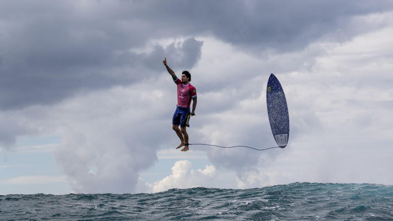 Årets sportbild alla kategorier. Brouillet tog bilden under surfingtävlingen vid OS i Paris. Från en båt vid sidan av vågen i Tahiti fångade Brouillet Gabriel Medina svävande i luften, som om han stod på fast mark, medan hans bräda speglade hans hållning. Foto: Jerome Brouillet