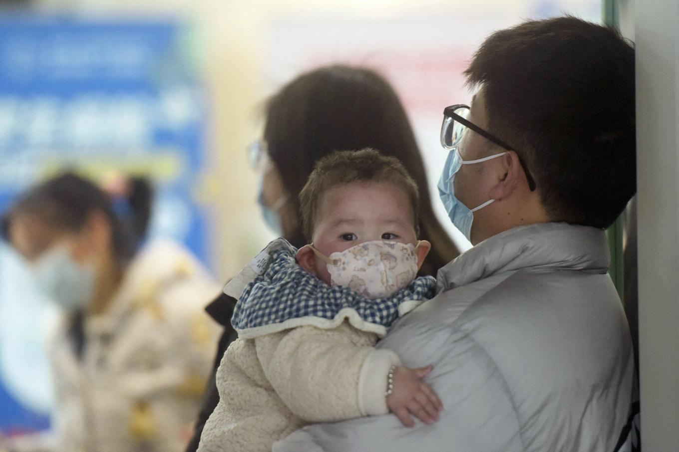 En familj med munskydd väntar på barnavdelningen på ett sjukhus i Hangzhou i östra Kina den 6 januari i år. Den senaste tiden har en ökning av det influensaliknande viruset HMPV rapporterats och orsakat sjukdom hos framförallt barn. Foto: STR/AFP via Getty Images