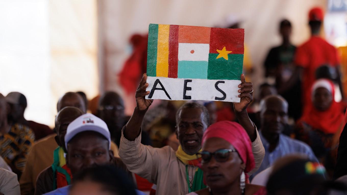 En man i Mali håller upp en skylt till stöd för det nya samarbetet AES för att fira att Mali, Niger och Burkina Faso dragit sig ur samarbetet Ecowas och bildat den nya organisationen. Foto: Gousno/AFP via Getty Images