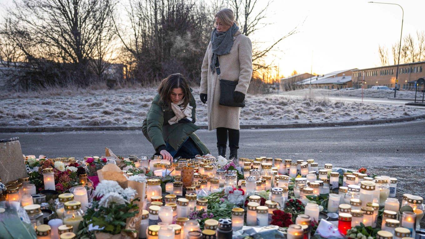 Människor tänder ljus och lägger blommor för att visa sin vördnad för dem som dog på Campus Risbergska i Örebro. Foto: Jonathan Näckstrand/AFP via Getty Images