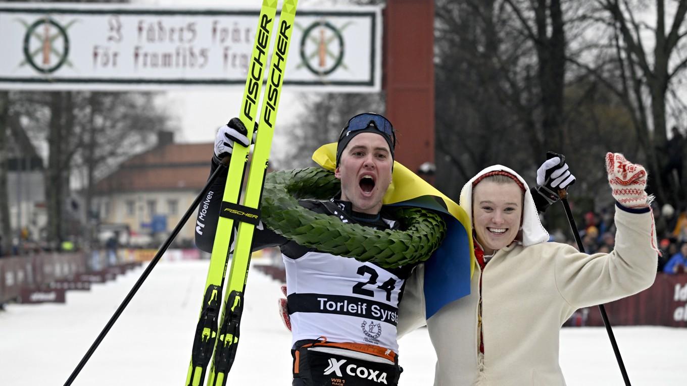 Torleif Syrstad från Norge gratuleras av kranskullan Elsa Hermansson i Mora när han vann Vasaloppet 2024. Det var det hundrade loppet i historien. Foto: Ulf Palm/SVT