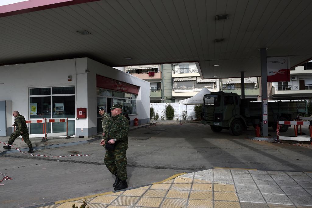 Militär personal lämnar den bensinmack där en odetonerad bomb hittats på omkring fem meters djup. Foto: Giannis Papanikos/AP/TT