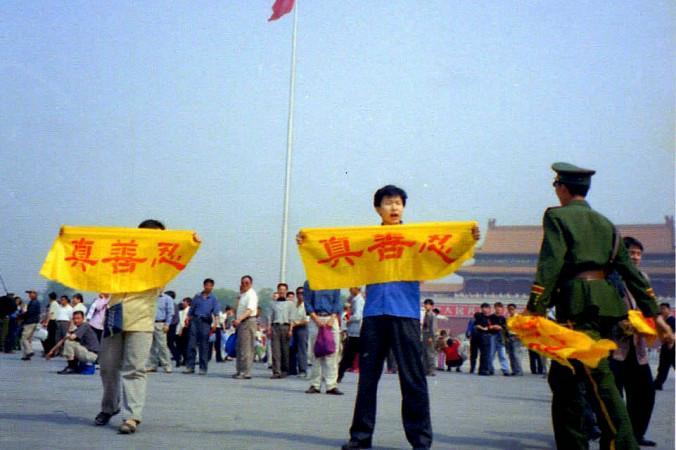

Falungong-utövare som håller upp banderoller med tecknen för falungongs principer,"sanning, godhet, tålamod" på Himmelska fridens torg 2001 i en fredlig protest mot kommunistpartiets förföljelse. Foto via minghui.org                                                                                        