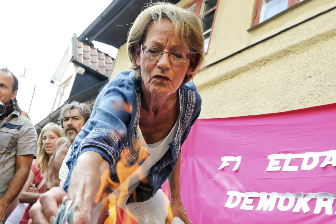 
Gudrun Schyman, FI:s ordförande, eldar upp pengar under Almedalsveckan 2010. Foto: Janerik Henrikson/AFP/Getty Images                                            