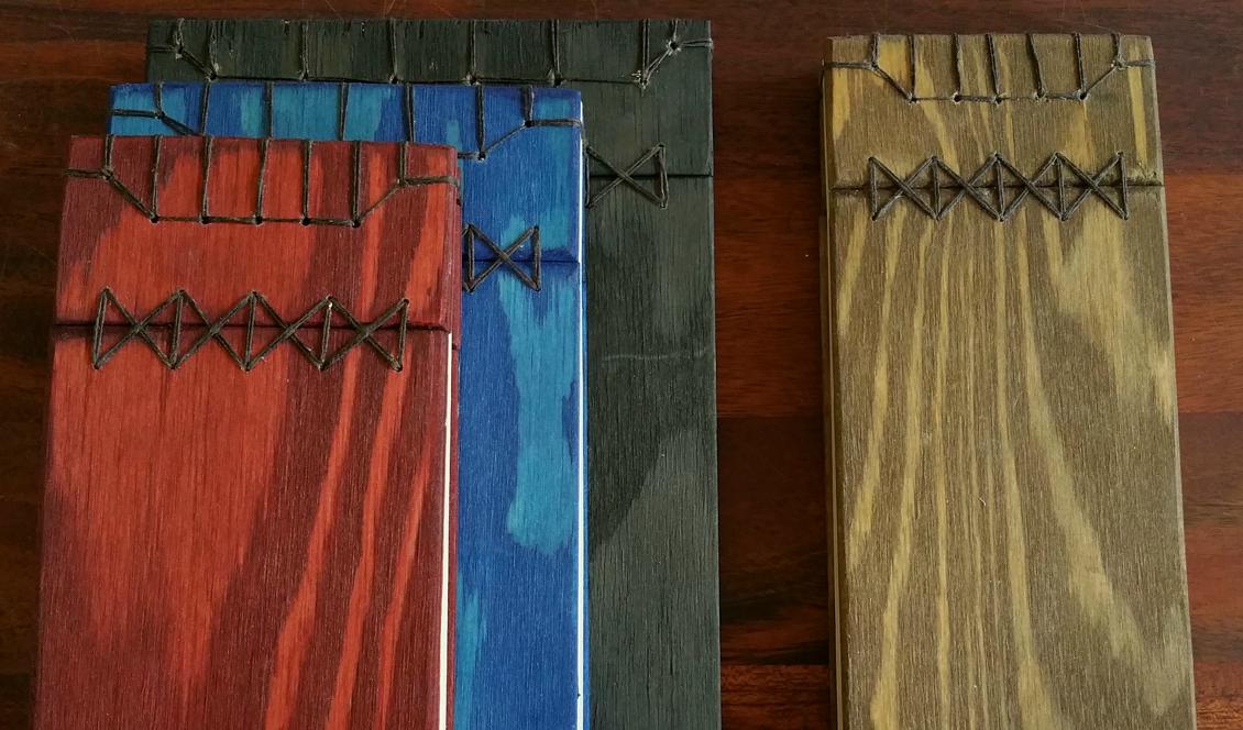 Fyra japanskt bundna böcker betsade i olika färger. Foto: Anton Nilsson