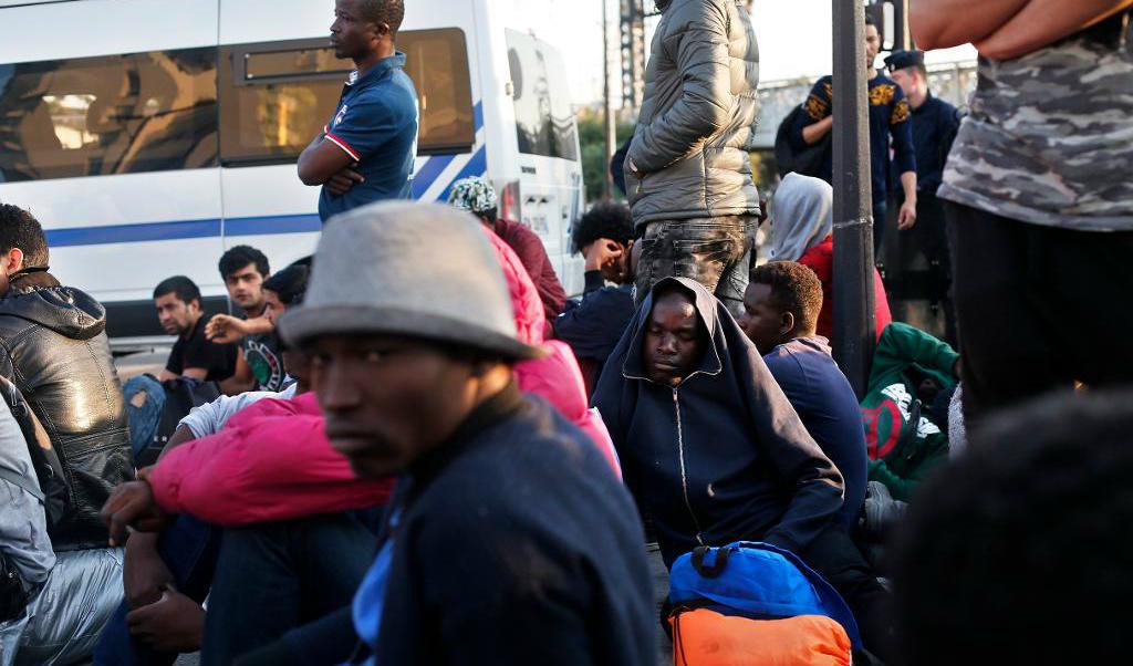 
Migranter väntar på att bli förflyttade från ett provisoriskt gatuläger i Paris. Foto: Thibault Camus/AP/TT                                            