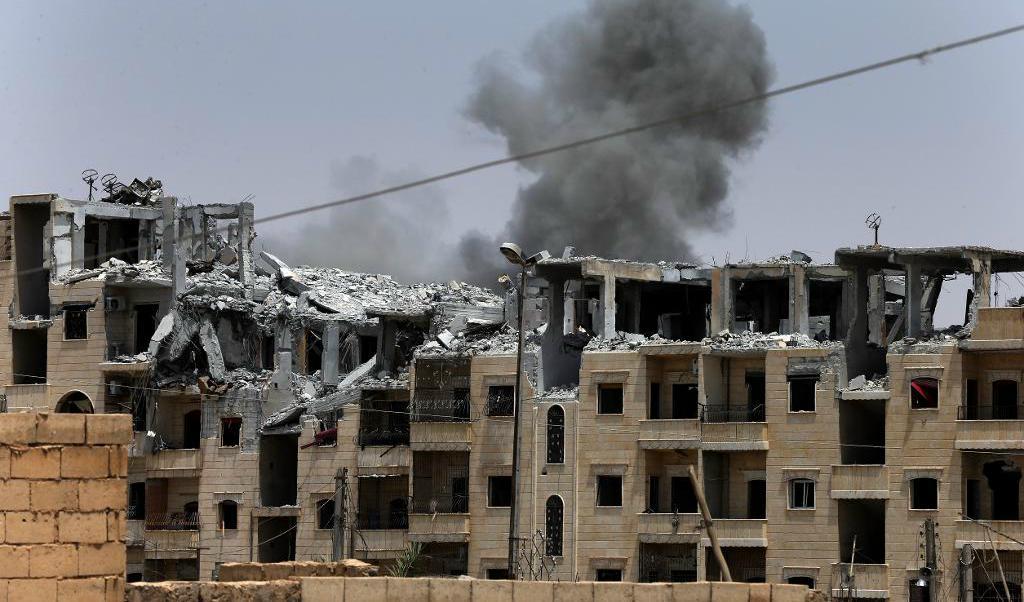 
Rök stiger från ett område i al-Raqqa i nordöstra Syrien efter ett flyganfall. Foto: Hussein Malla/AP/TT                                            
