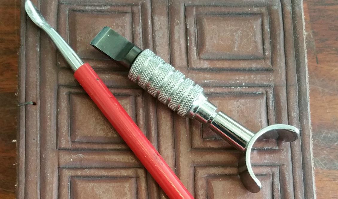 En läderbok samt de verktyg jag huvudsakligen använder när jag gör mina mönster. Foto: Anton Nilsson