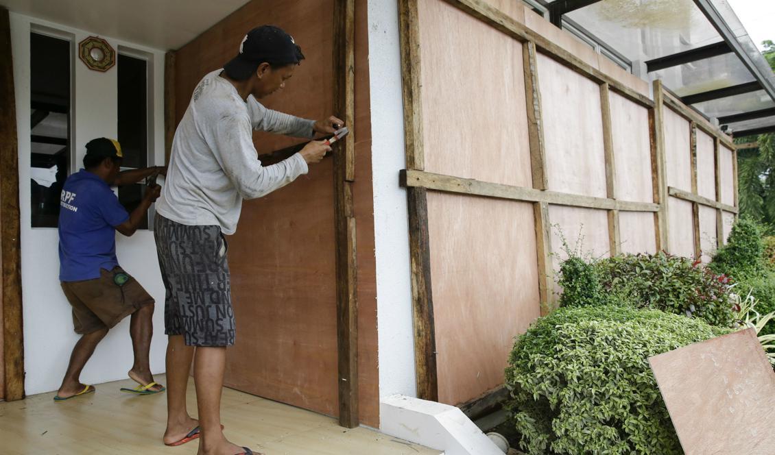 Arbetare spikar för fönstren på ett hotell i provinsen Cagayan i norra Filippinerna. Foto: Aaron Favila/AP/TT