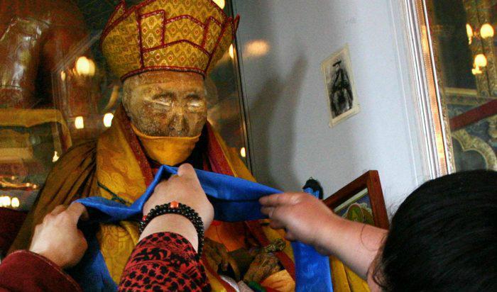 



En odaterad bild visar en troende som dekorerar mumien av den buddhistiske ledaren Dasha-Dorjo Itigelov som känns och ser ut likadant som när han dog 1927 i Ulan-Ude. Foto: HO/AFP/Getty Images                                                                                                                                                                                