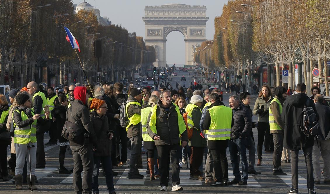 Demonstranter blockerar paradgatan Champs-Élysées i Paris vid lördagens omfattande demonstration mot höjda bensinpriser i Frankrike. Foto: Michel Euler/AP/TT