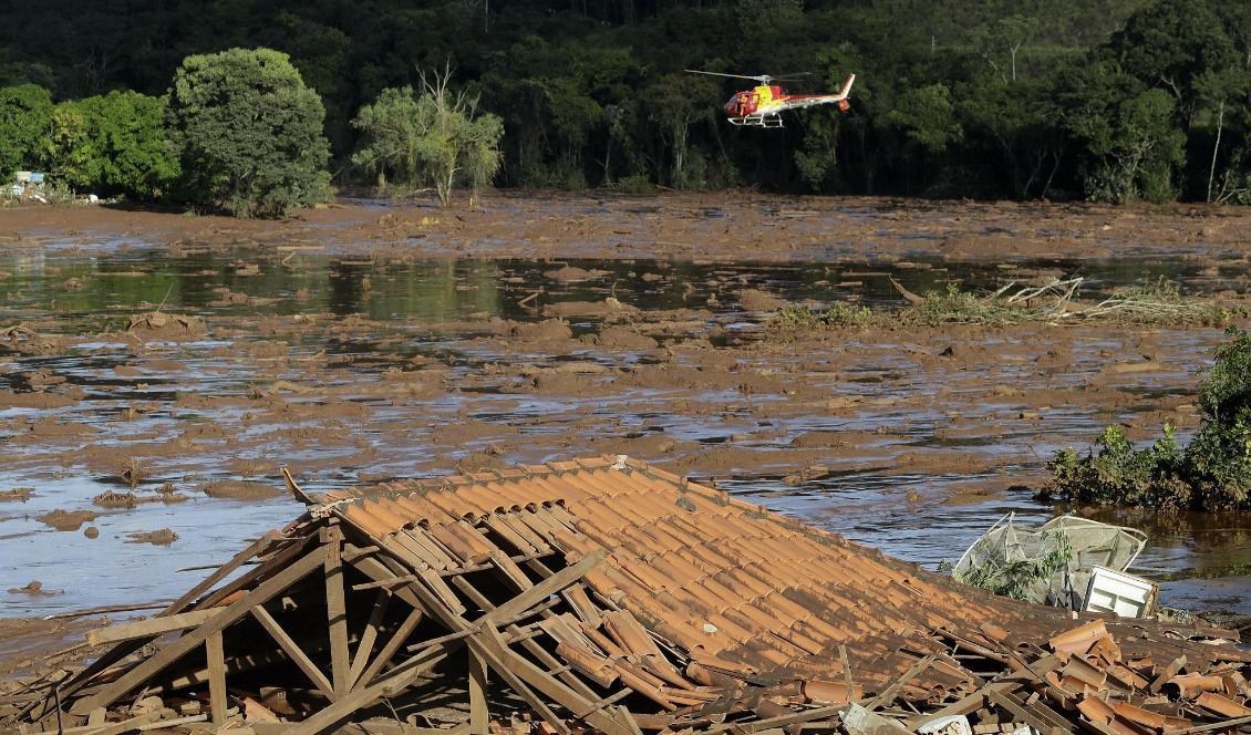 Helikopterburna räddningsarbetare letar offer efter dammkollapsen. Foto: Andre Penner/AP/TT