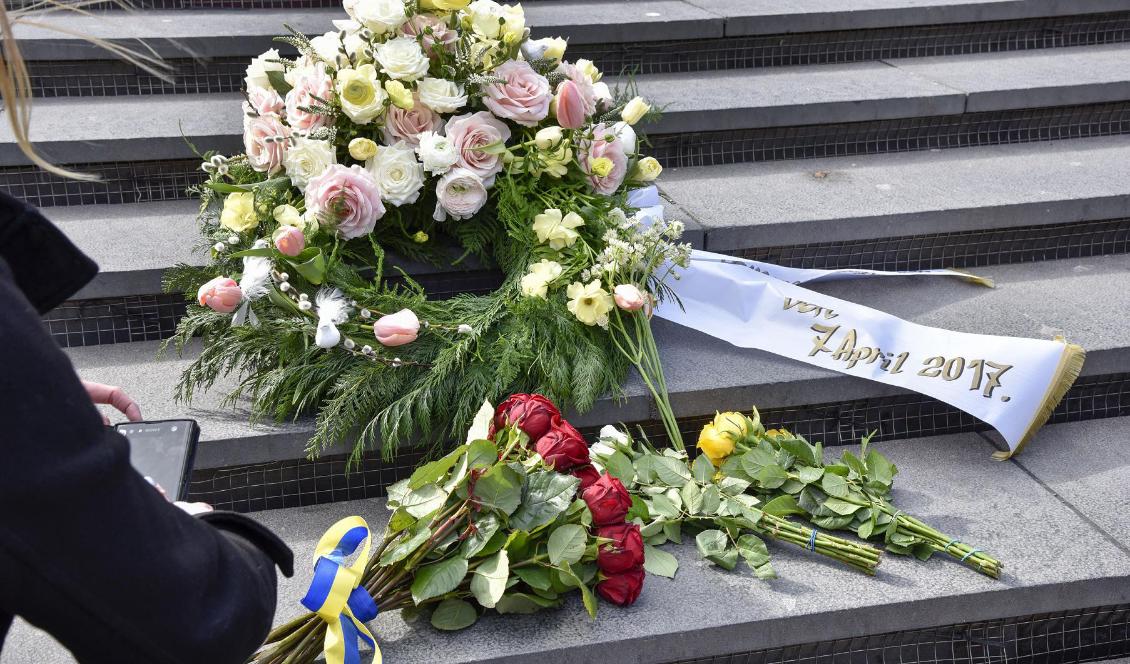 En krans och blommor har lagts i trappan vid Sergels torg för att hedra offren för terrordådet på Drottninggatan för två år sedan. Foto: Lars Schröder/TT