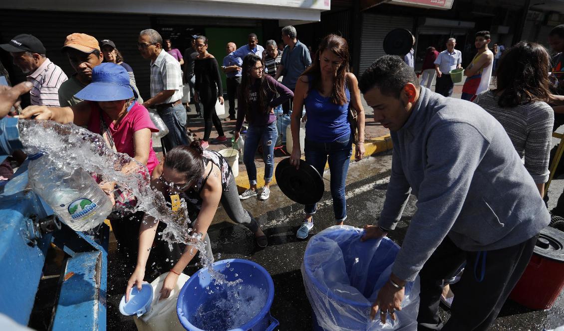 Caracasbor samlar vatten från ett vattentankfordon under det flera dagar långa strömavbrottet i Venezuela nyligen. Foto: Eduardo Verdugo/AP/TT