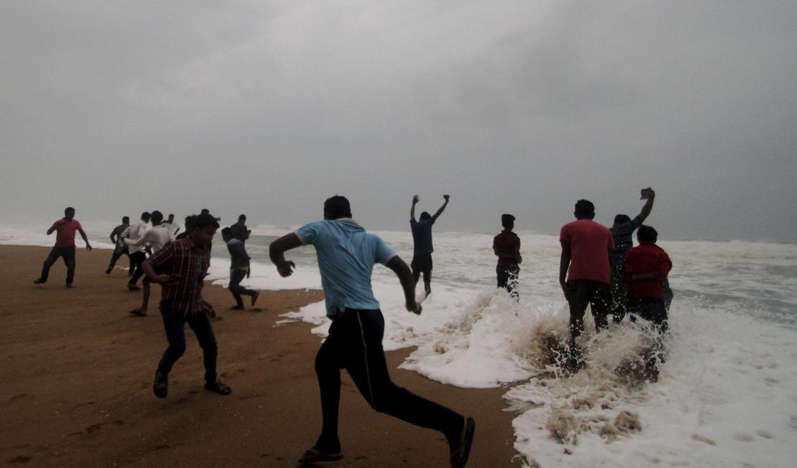 Personer springer undan tidvattnet på en strand i Puri, i delstaten Odisha. Foto: STR/TT