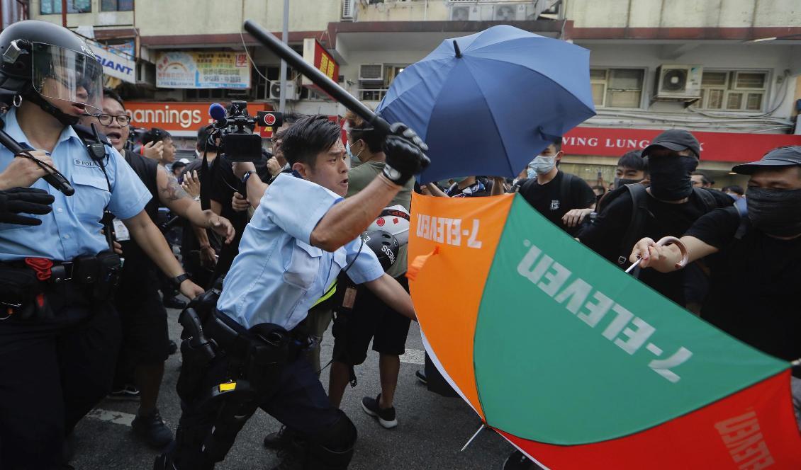 En polis går till attack mot demonstranter i Hongkong under lördagens protester. Foto: Kin Cheung/AP/TT