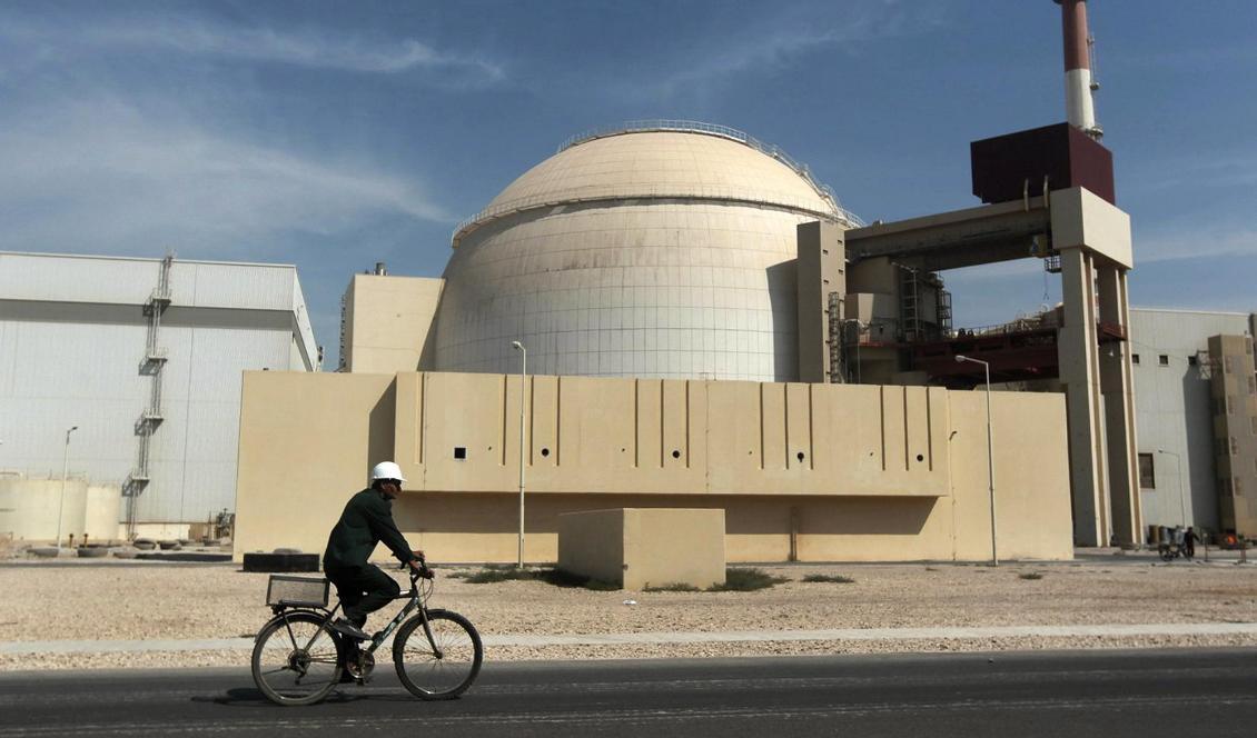En man cyklar förbi en kärnkraftreaktor utanför staden Bushehr i Iran. Foto: Majid Asgaripour/AP/TT-arkivbild