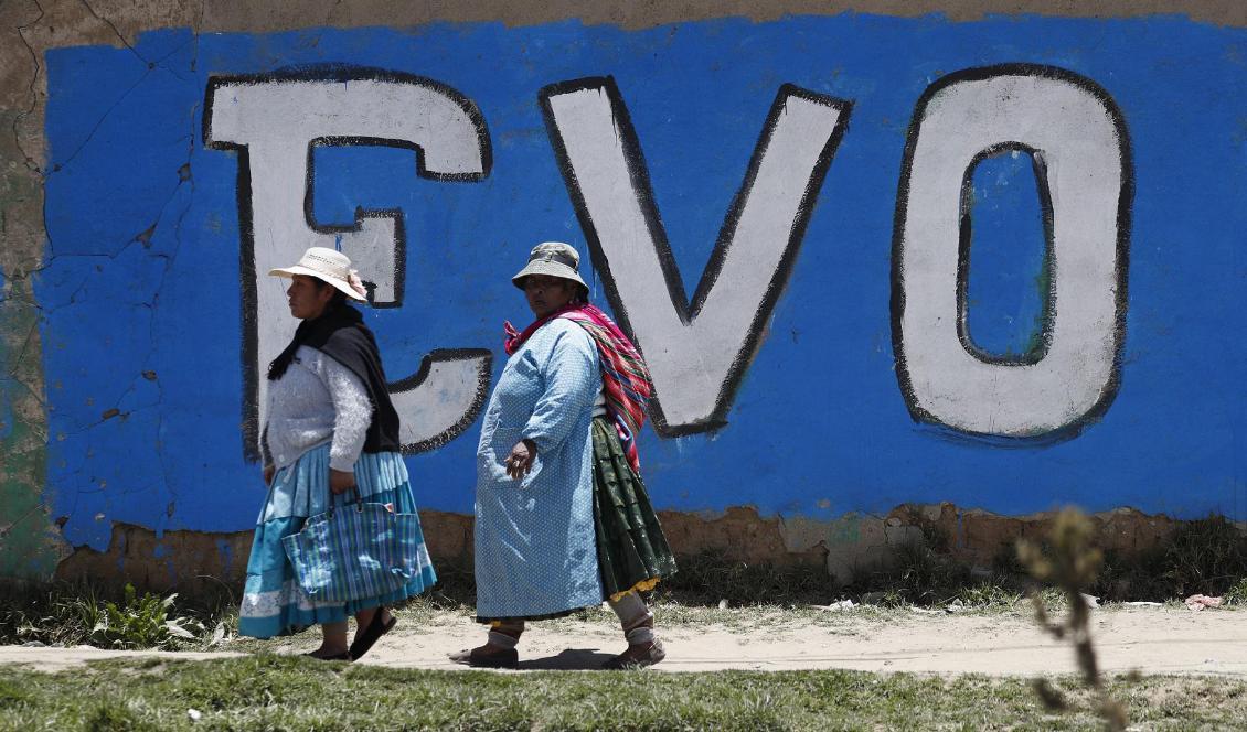 Anhängare till ex-presidenten Evo Morales passerar en väggmålning i El Alto, en förstad till huvudstaden La Paz där det bor många människor från Bolivias ursprungsbefolkning. Bilden är tagen den 20 november. Foto: Natacha Pisarenko/AP/TT