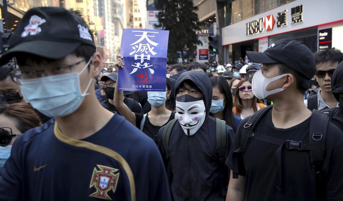 Demonstranter i Hongkong trotsar maskeringsförbudet under lördagens demonstration. Foto: Kin Cheung/AP/TT