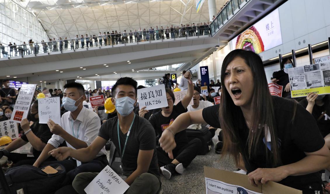 
Demonstranter skriker slagord under en protest på Hongkongs flygplats under fredagen den 26 juli 2019. Foto: Vincent Yu/AP/TT                                                