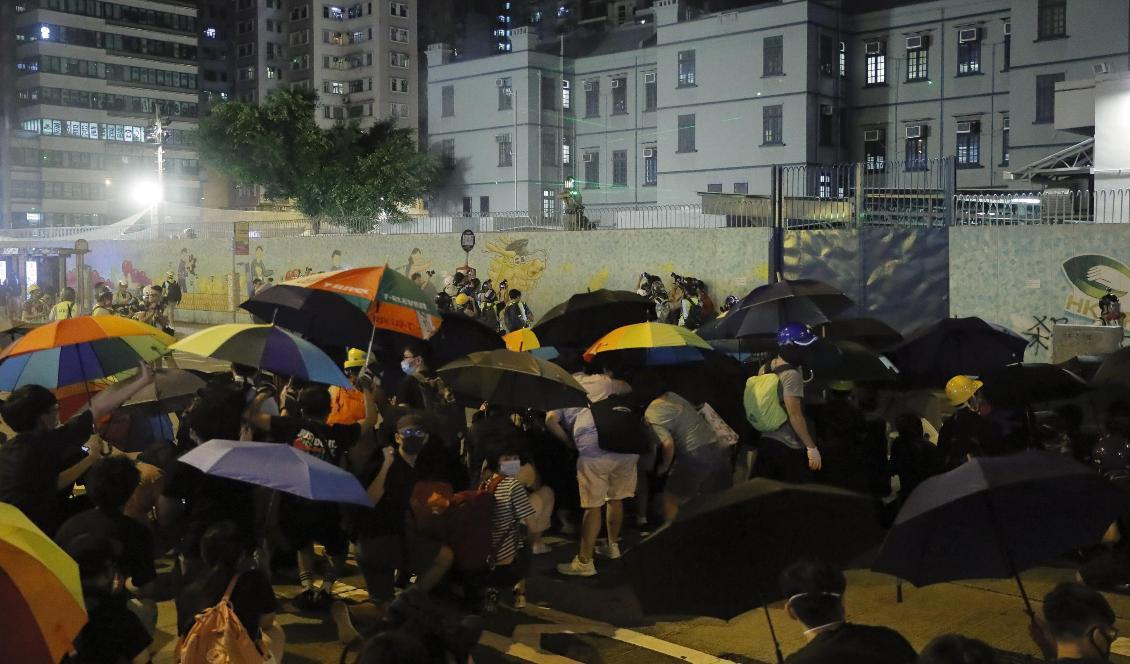 Poliser skjuter tårgas mot aktivister i Hongkong på fredagskvällen. Foto: Kin Cheung /AP/TT