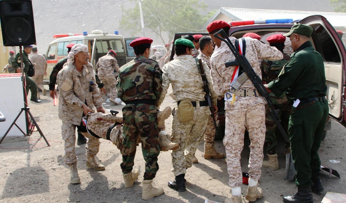 Soldater hjälper en skadad kollega efter attacken mot en militärparad i Aden, Jemen. Foto: Fawaz Salman/Reuters/TT