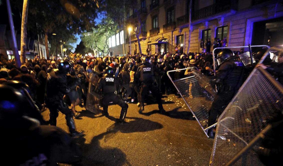 Kravallpolis och demonstranter drabbar samman utanför den spanska regeringsbyggnaden i Barcelona på tisdagskvällen. Foto: Emilio Morenatti/AP/TT