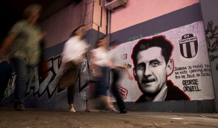 Människor passerar förbi en bild av den brittiske författaren George Orwell med texten "Frihet är rätten att säga till människor det de inte vill höra", i Belgrad den 8 maj 2018. Foto: Oliver Bunic/AFP/Getty Images