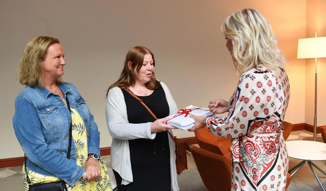 Undersköterskorna Jenny Klingstam och Mari Wiberg lämnar över namninsamlingen från undersköterskeuppropet till socialminister Lena Hallengren (S). Foto: Fredrik Sandberg/TT