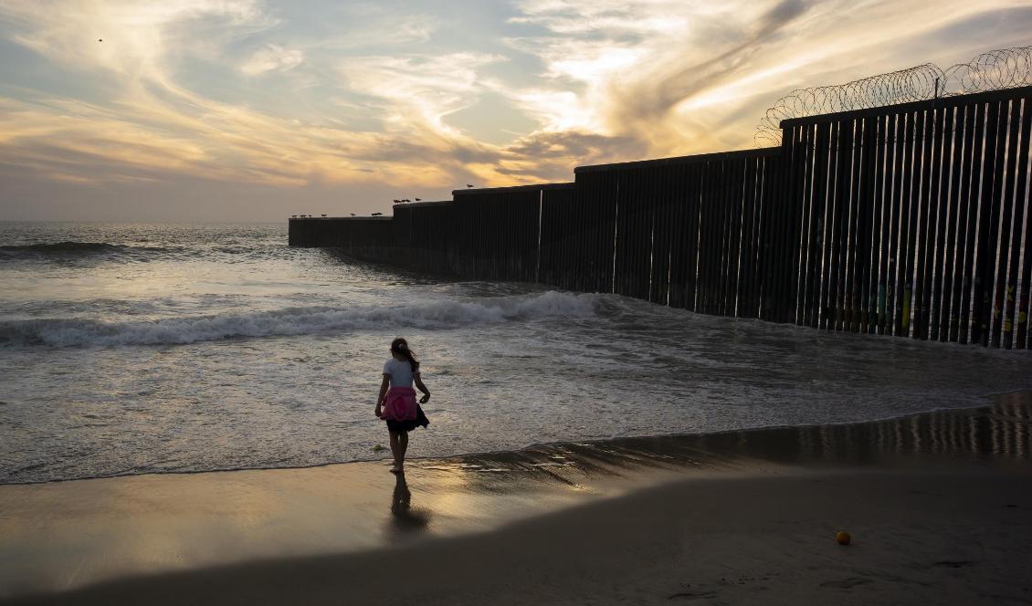 En flicka vid gränsmuren som separerar San Diego och Tijuana i Kalifornien. Foto: Gregory Bull/AP/TT-arkivbild