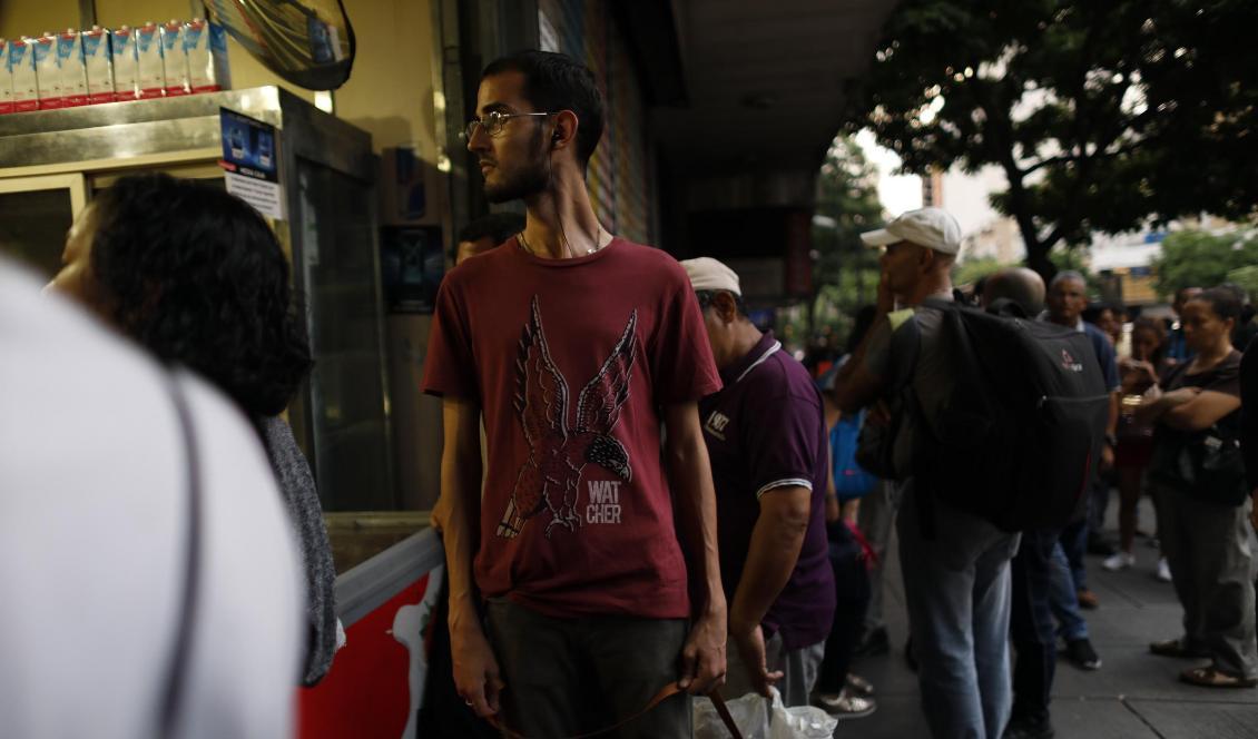 Människor på mörklagda gator i Caracas på måndagskvällen. Foto: Ariana Cubillos/AP/TT