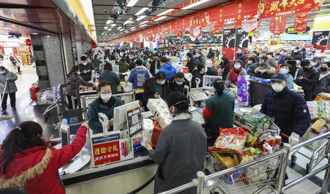 

Invånare i Wuhan handlar mat med ansiktsmasker på. Foto: Chinatopix/AP/TT                                                                                                