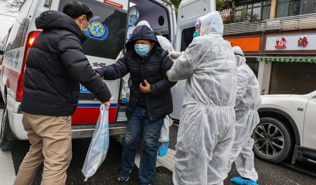 En patient får hjälp ur ambulansen av vårdpersonal som bär skyddskläder mot det dödliga coronaviruset, den 26 januari i Wuhan, Kina. Foto: STR/AFP via Getty Images