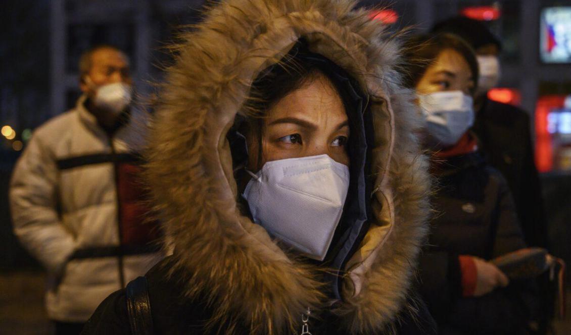 Kinesiska personer bär skyddsmask när de står och väntar på bussen efter arbetsdagens slut i Peking, Kina den 2 mars, 2020. Foto: Kevin Frayer, Getty Images