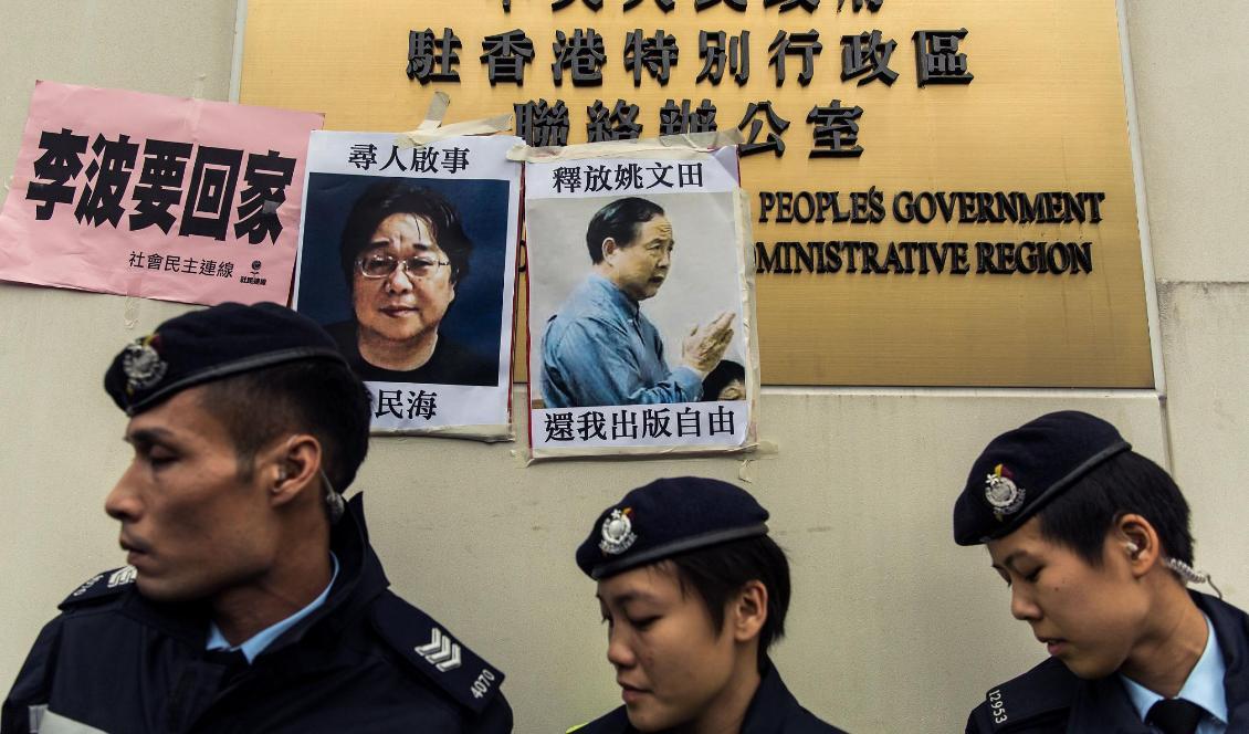 



Poliser går förbi ett anslag om den saknade Gui Minhai, som nyligen dömts till tio års fängelse i Kina. Foto: Anthony Wallace/AFP via Getty Images                                                                                                                                                                                            