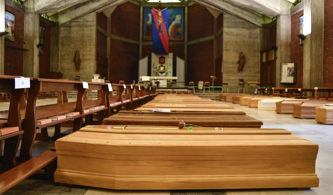 Kistor som ska vidare till ett krematorium ligger på golvet i San Giuseppe-kyrkan Seriate i provinsen Bergamo i Italien. Foto: Claudio Furlan/AP/TT