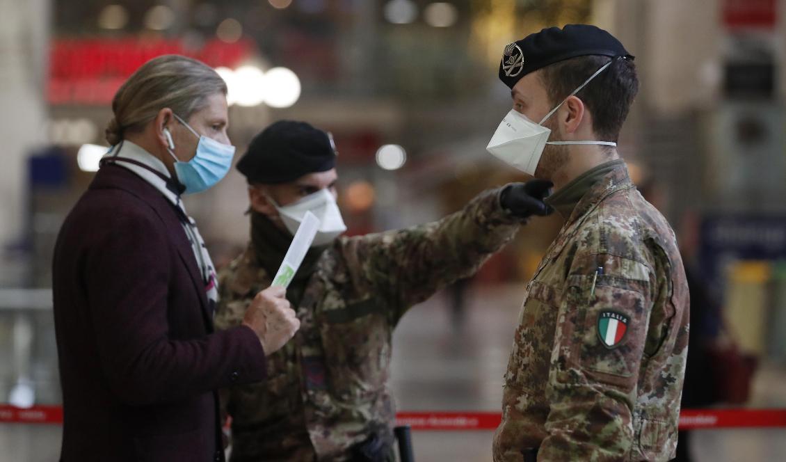 Resande på centralstationen i Milano kontrolleras av militär. Foto: Antonio Calanni/AP/TT