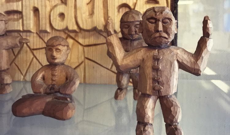 Täljda trägubbar som mediterar Falun Gong. Foto: Anton Nilsson