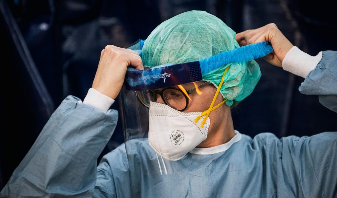 Sjuksköterskan Renee Jarvalt tar på sig skyddsutrustning i ett tält vid Sophiahemmet i Stockholm den 22 april 2020. Foto: Jonathan Nackstrand/AFP via Getty Images