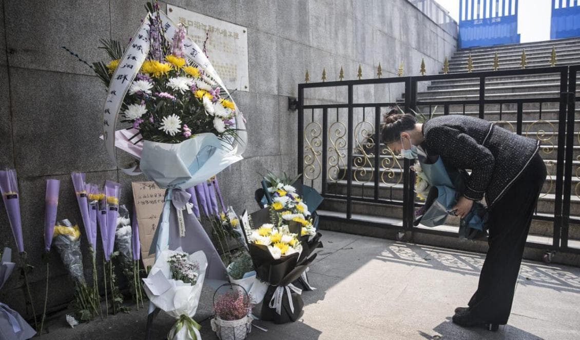 En kinesisk kvinna lämnar blommor under en minnesstund för de som dött i kampen mot KKP-viruset. Hubeiprovinsen i Kina, den 4 april 2020. Foto: Getty Images