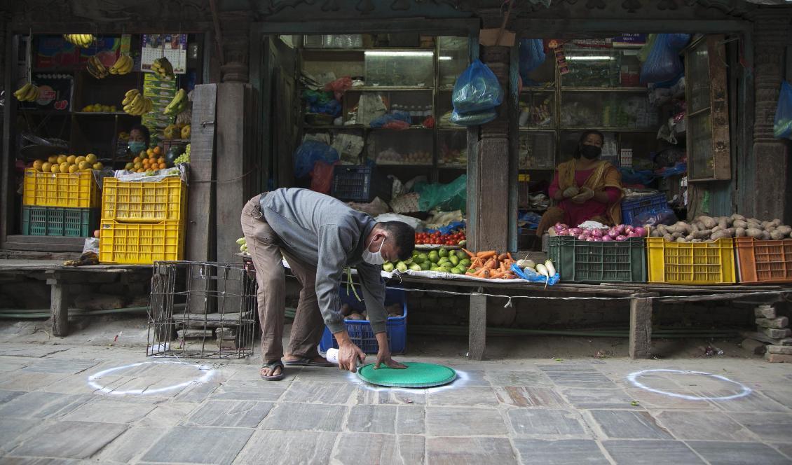 En butiksägare markerar avstånd för social distansering utanför sin butik i Nepals huvudstad Katmandu. Sedan den 24 råder stränga restriktioner i Nepal på grund av coronavirusets spridning. Foto: Niranjan Shrestha/AP/TT
-arkivbild