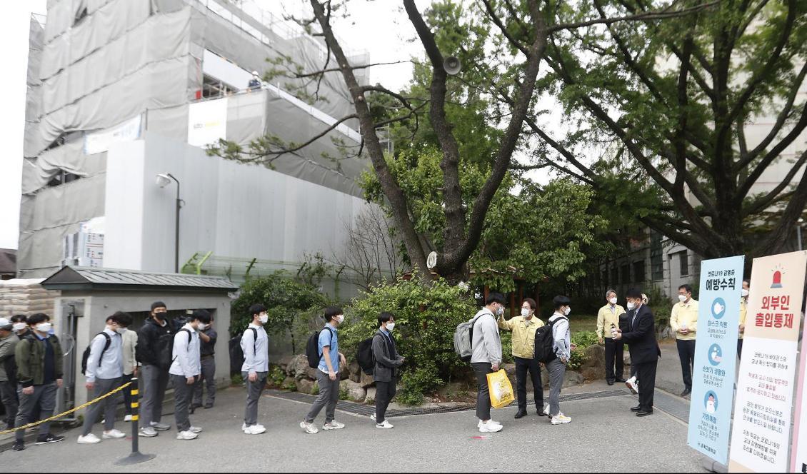 Elever köar för att få sin kroppstemperatur kontrollerad vid en skola i Seoul. Foto: Ahn Young-Joon/AP/TT