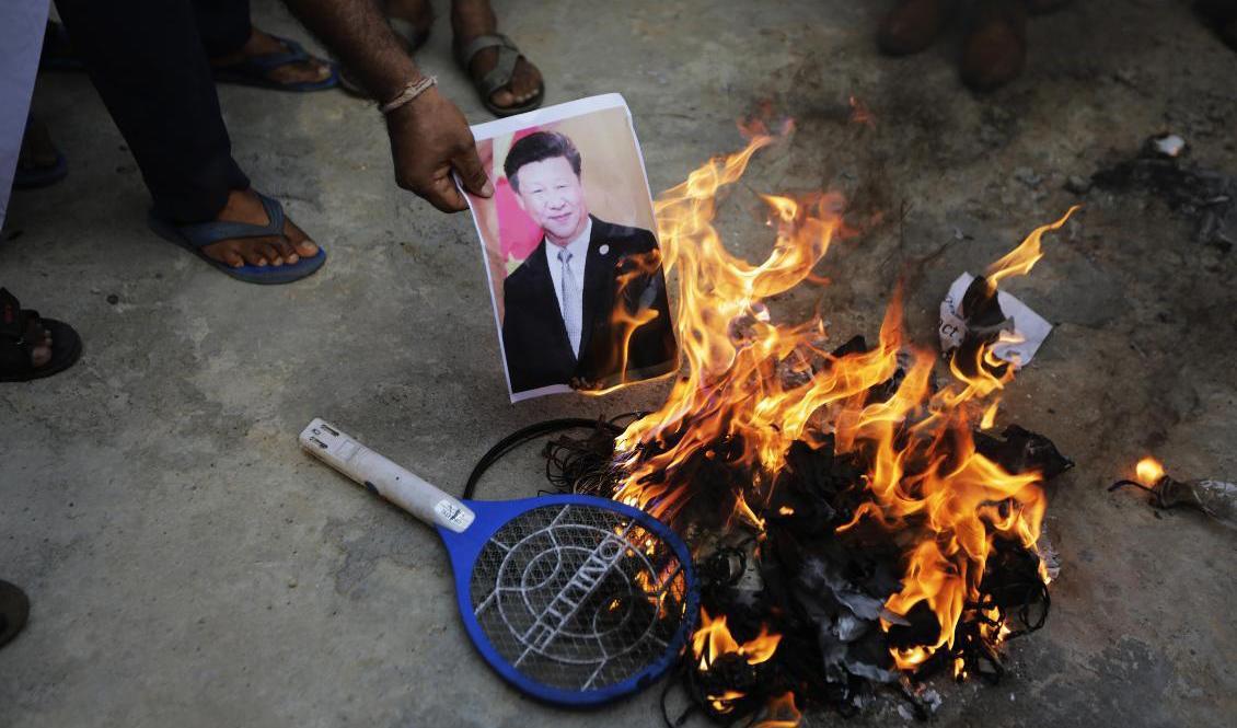 Demonstranter i indiska Ahmedabad bränner ett fotografi av Kinas president Xi Jinping efter att den latenta gränskonflikten mellan länderna blossat upp. Foto: Ajit Solanki/AP/TT