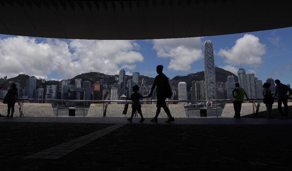 Människor lördagsflanerar vid Victoria Harbor i Hongkong. Foto: Kin Cheung/AP/TT